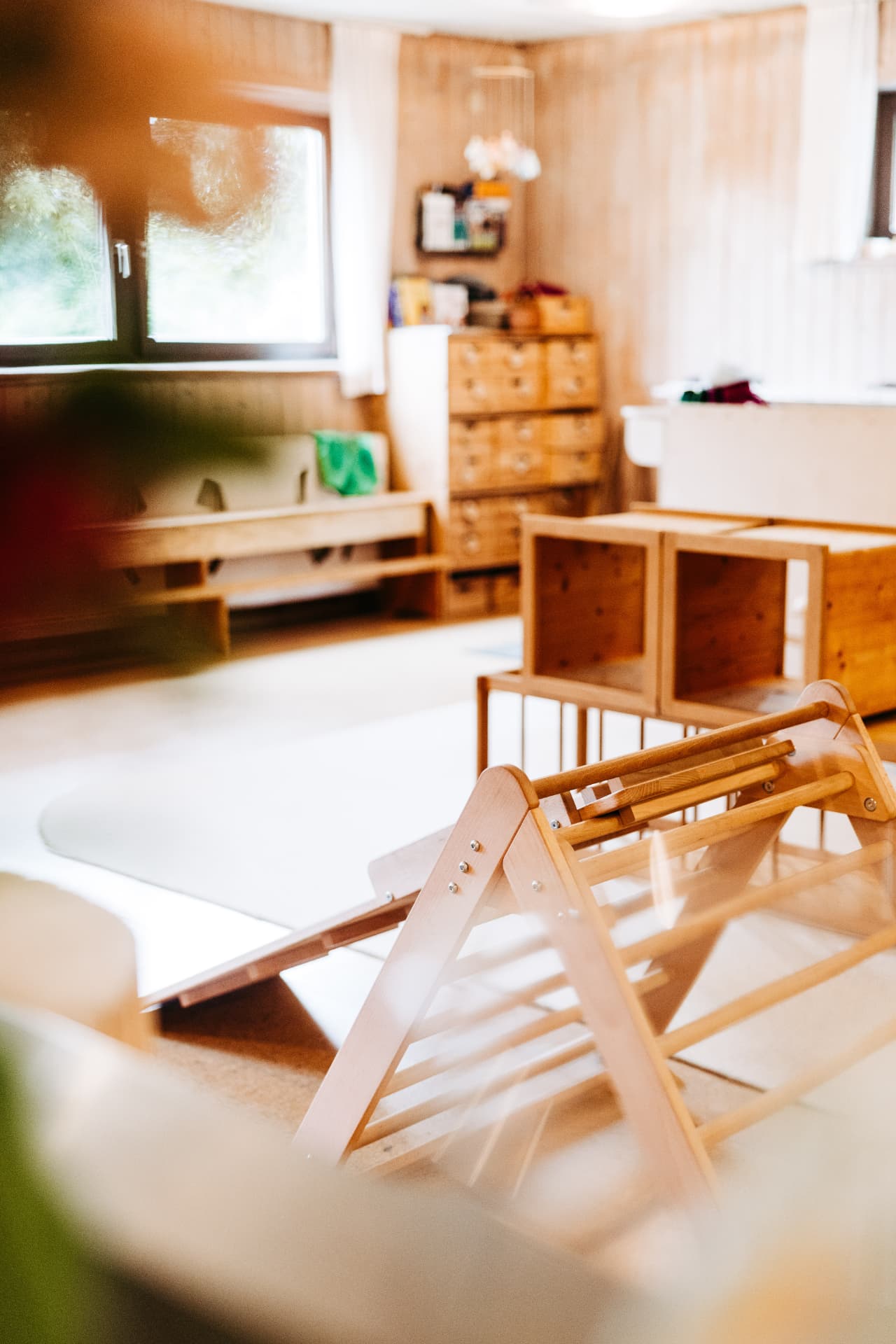 Heller Spielraum mit Holzmaterial und Kletterdreieck
